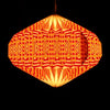 A glowing orange and red hexagonal paper lantern with a geometric origami pattern in a warm light shade