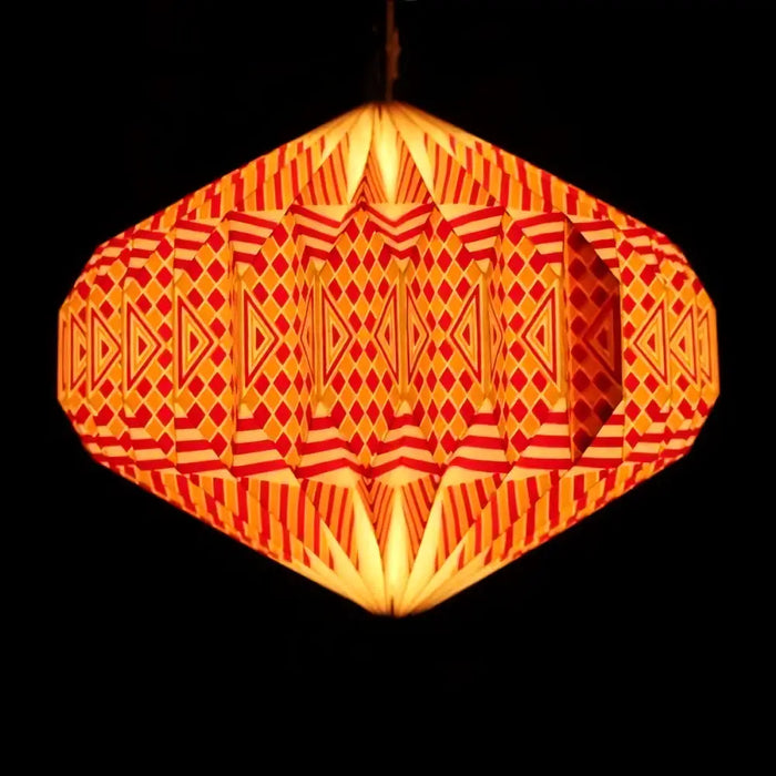 A glowing orange and red hexagonal paper lantern with a geometric origami pattern in a warm light shade