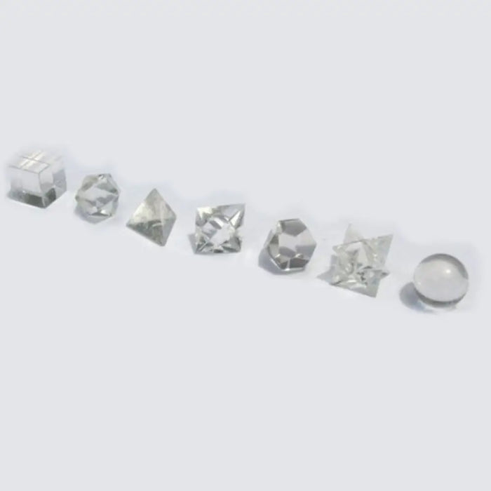 Clear quartz geometric seven piece crystal set with faceted dice and a spherical glass ball in a row