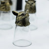 A clear glass shot glass topped with an antique bronze owl stopper from mystical creatures shot glasses set
