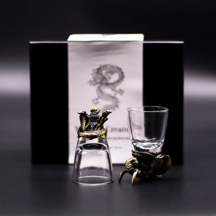 A clear glass shot glass with a golden dragon stopper and an elephant base from mystical creatures shot glasses set