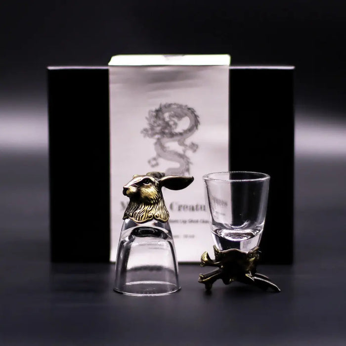 A clear glass shot glass with a golden rabbit stopper and base from mystical creatures shot glasses gift set