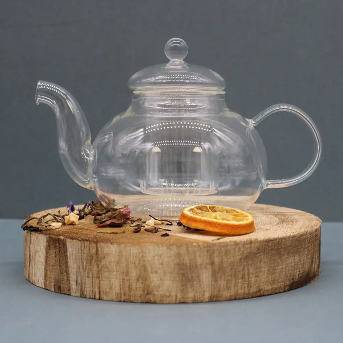 Clear glass infuser teapot with rounded body and curved spout featuring an internal infuser for loose tea leaves