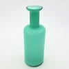 A sleek teal glass reed diffuser bottle with a translucent cylindrical body and a slender neck vase design