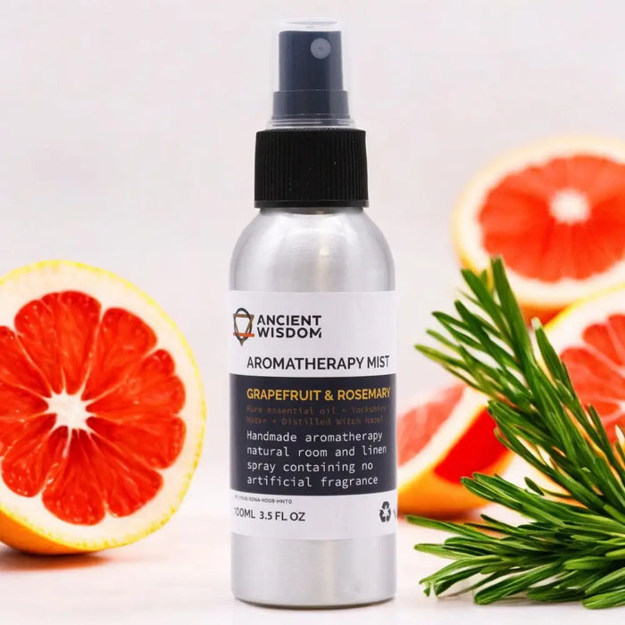 A sleek silver spray bottle labeled ancient wisdom aromatherapy mist with grapefruit and rosemary essential oil to reduce stress levels