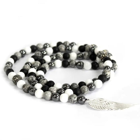 A coiled grey agate necklace with black white and gray stone beads and a silver angel wing charm