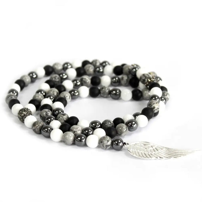 A coiled grey agate necklace with black white and gray stone beads and a silver angel wing charm