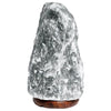 A grey himalayan salt lamp with rough texture and natural stone look on a dark brown wooden base showing hygroscopic properties