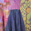 Gringo fairtrade smock dress with a purple v-neck bodice and navy blue pleated skirt in two-toned purple green style