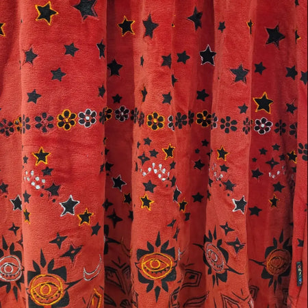 Red velour tunic dress with embroidered black stars yellow outlined flowers and orange white eye motifs