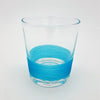 Clear glass votive with a vibrant blue ribbed band near the base used as a tealight holder in four colour options