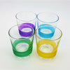 Set of four glass votive tealight holders with colorful horizontal stripes in purple blue green and yellow near the base