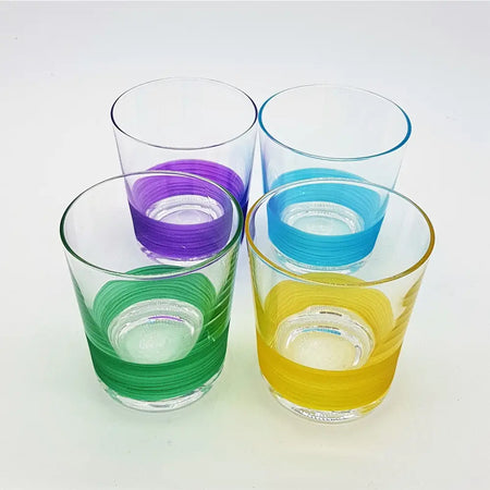 Set of four glass votive tealight holders with colorful horizontal stripes in purple blue green and yellow near the base