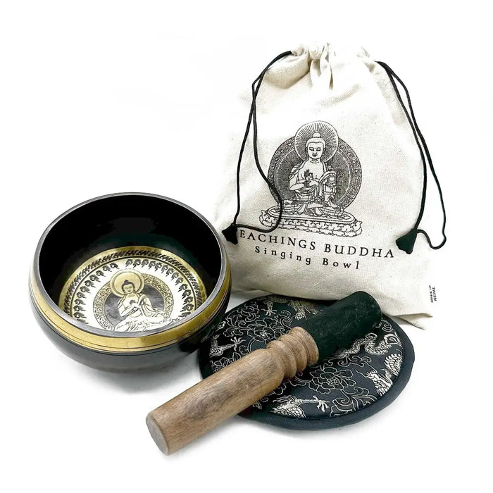Black hand-beaten engraved singing bowl with gold rim and buddha design with wooden mallet in a bowl gift set