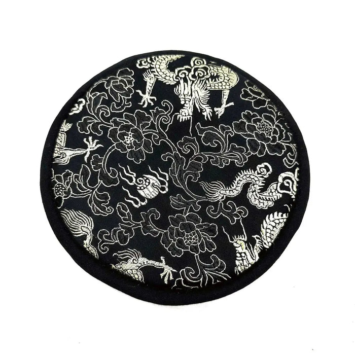 Black circular cushion with white embroidered dragons and floral patterns for engraved singing bowl gift lotus flower set