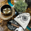 A polished bronze engraved singing bowl with golden geometric pattern resting on a wooden stand in a bowl gift set