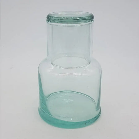Clear glass jug with a rounded base and green recycled glass tint hand blown for serving water or drinks