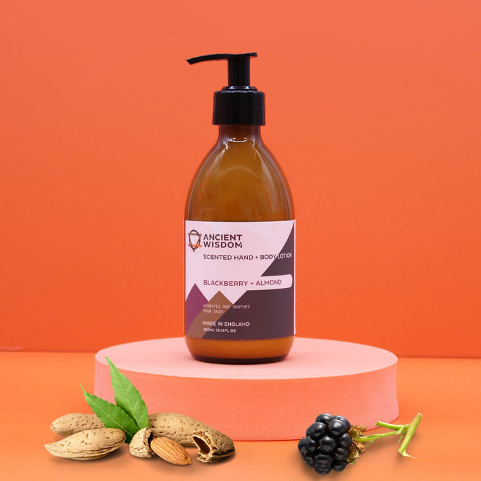A sleek amber glass bottle of ancient wisdom body lotion with black pump in blackberry and almond seed oil scent