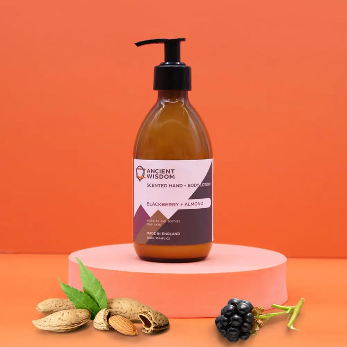 A sleek amber glass bottle of ancient wisdom body lotion with black pump in blackberry and almond seed oil scent