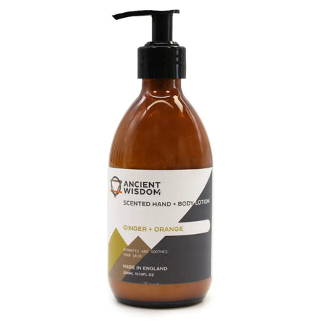 A sleek amber glass body lotion bottle with black pump labeled ancient wisdom scented hand and body lotion ginger orange
