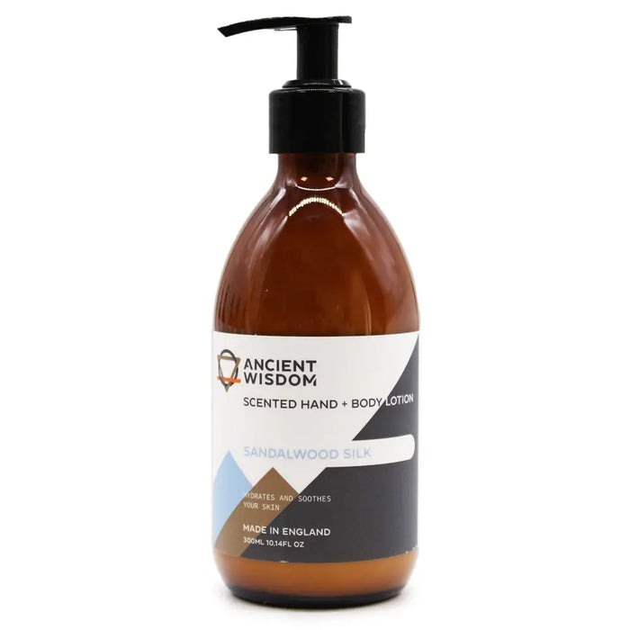 A sleek amber glass bottle of ancient wisdom hand and body lotion sandalwood silk with black pump dispenser and seed oil