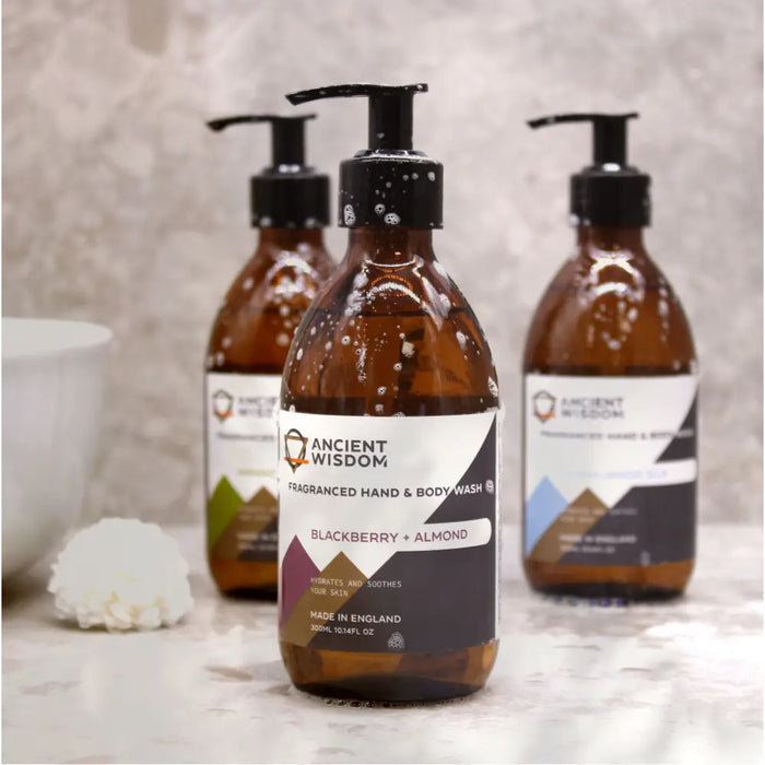 Amber glass bottle of hand and body wash with black pump dispenser in blackberry almond scent and fruity scent label