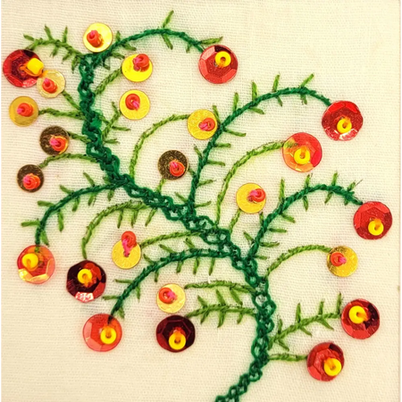 Hand-embroidered christmas card with green christmas tree stitched branches and red yellow sequined berries on fabric