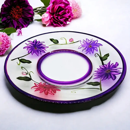 A hand-painted glass candle plate with purple wild flowers on a white base and a matching purple inner ring