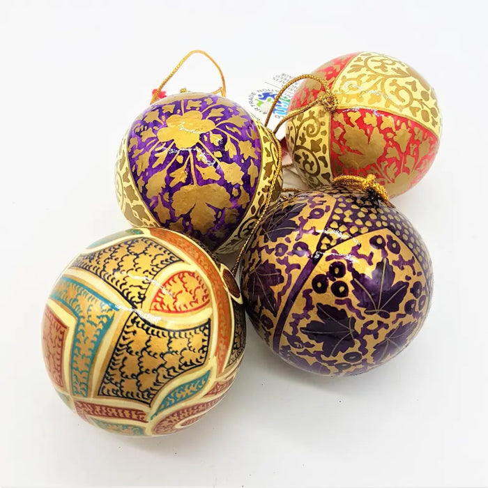 Hand-painted papier maché bauble with cream leaves and gold purple red teal patterns on a glossy surface
