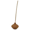A slender earthy brown incense stick stands upright in a handcrafted terracotta incense stick holder round by shoeless joe