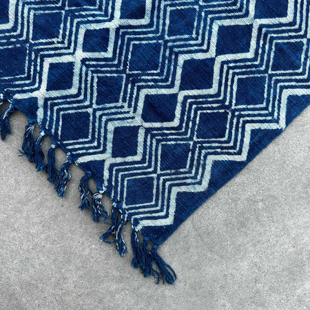 Handmade indigo runner featuring a deep indigo cotton textile with a bold white geometric heerak pattern and fringed edges