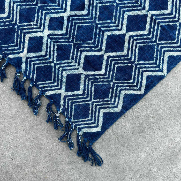 Handmade indigo runner featuring a deep indigo cotton textile with a bold white geometric heerak pattern and fringed edges