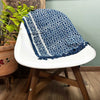 A handmade indigo runner with blue and white floral pattern frayed edges and geometric border made of textile