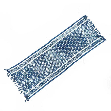 Handmade indigo runner with blue and white madjid tile pattern and fringed edges on woven textile material