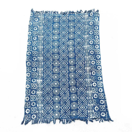 Handmade indigo throw with white geometric floral block print patterns and fringed edges in blue indigo cotton textile