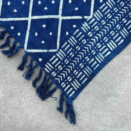 Handmade indigo throw in deep indigo cotton with white geometric tribal patterns and frayed blue tassels