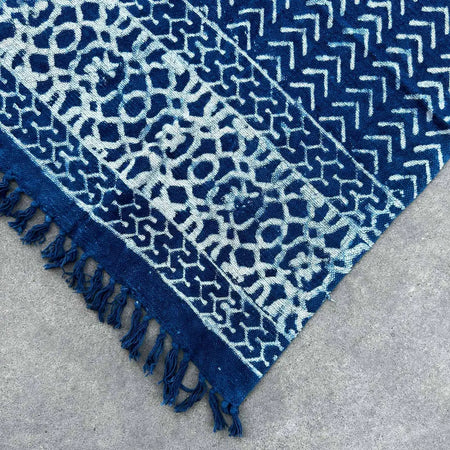 Handmade indigo throw with white block-print patterns on cotton fabric and fringed edges in seedha arrows design
