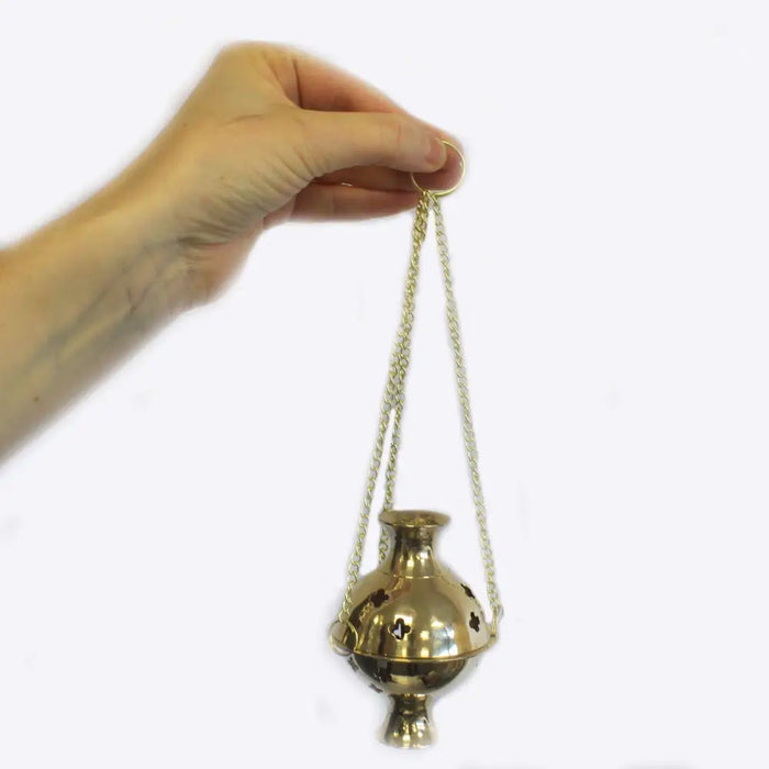 Gold-colored hanging brass incense burner with spherical body decorative cut-outs and chains for charcoal and resin use