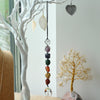 Hanging chakra stone pendant with seven colorful faceted crystals on black cord and clear glass globe bottom