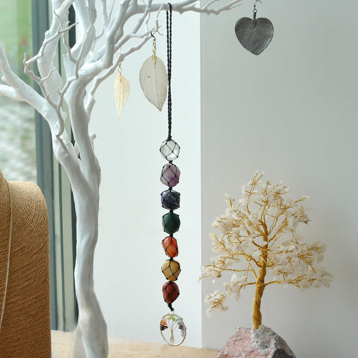 Hanging chakra stone pendant with seven colorful faceted crystals on black cord and clear glass globe bottom