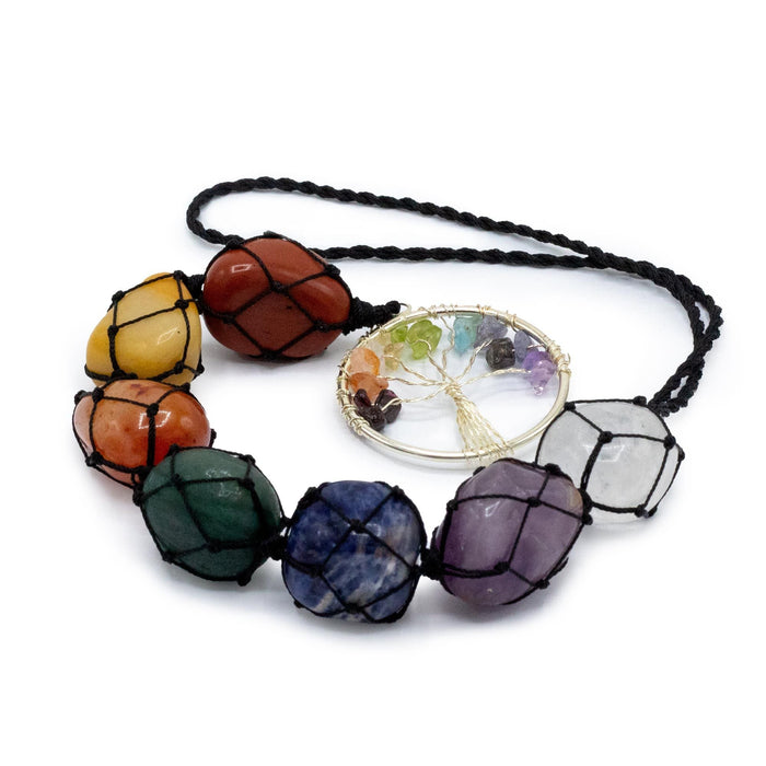 A seven chakra stone pendant necklace with colorful polished gemstones woven in black netting and a silver tree of life