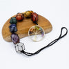 Hanging chakra stone pendant with a tree of life design, rainbow stones, black braided cord, and seven wrapped crystal beads