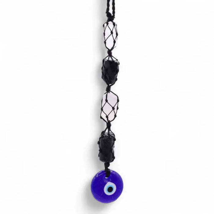 A vibrant blue glass evil eye pendant hanging from a black macrame cord with black tourmaline and selonite beads