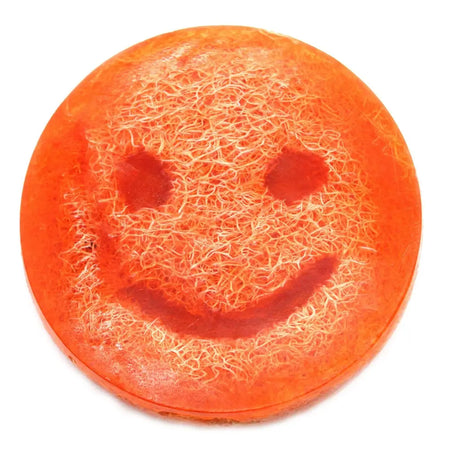 Happy scrub soap bar grapefruit is a vibrant orange circular scrub soap with a smiley face and fibrous texture