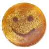 A round amber scrub soap bar with a smiling face design made of golden fibrous material inside