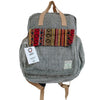 Hemp adventure backpack in gray herringbone with tan leather straps and a colorful woven patch with geometric designs