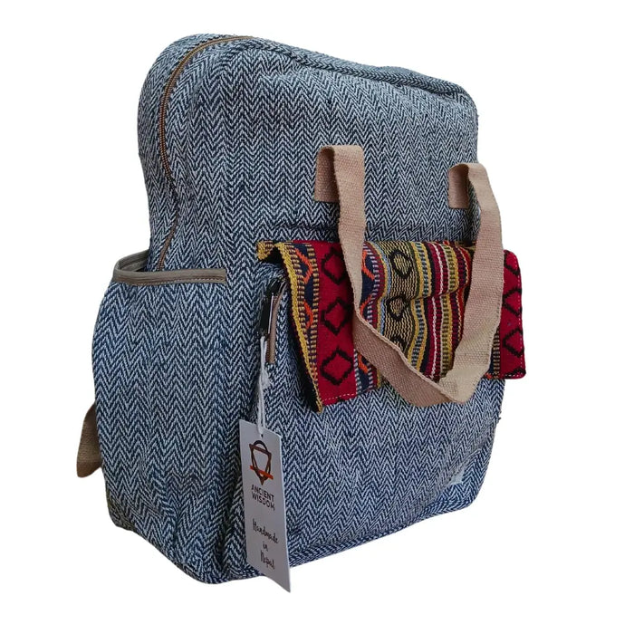 Hemp adventure backpack in blue herringbone with beige handles and a colorful woven fabric pocket made from hemp materials