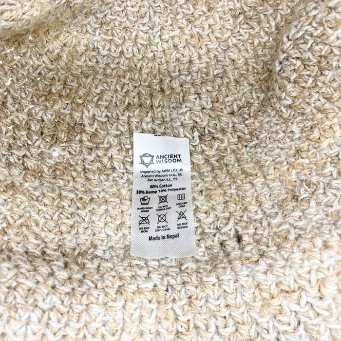 Beige knitted festival hat with textured cotton and hemp blend showing care label for cotton festival use