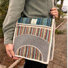 Handwoven multicolored laptop messenger bag with herringbone and striped natural fiber textile and cream trim
