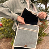 Beige and gray herringbone hemp laptop messenger bag with natural fiber texture cream trim and wooden button closure